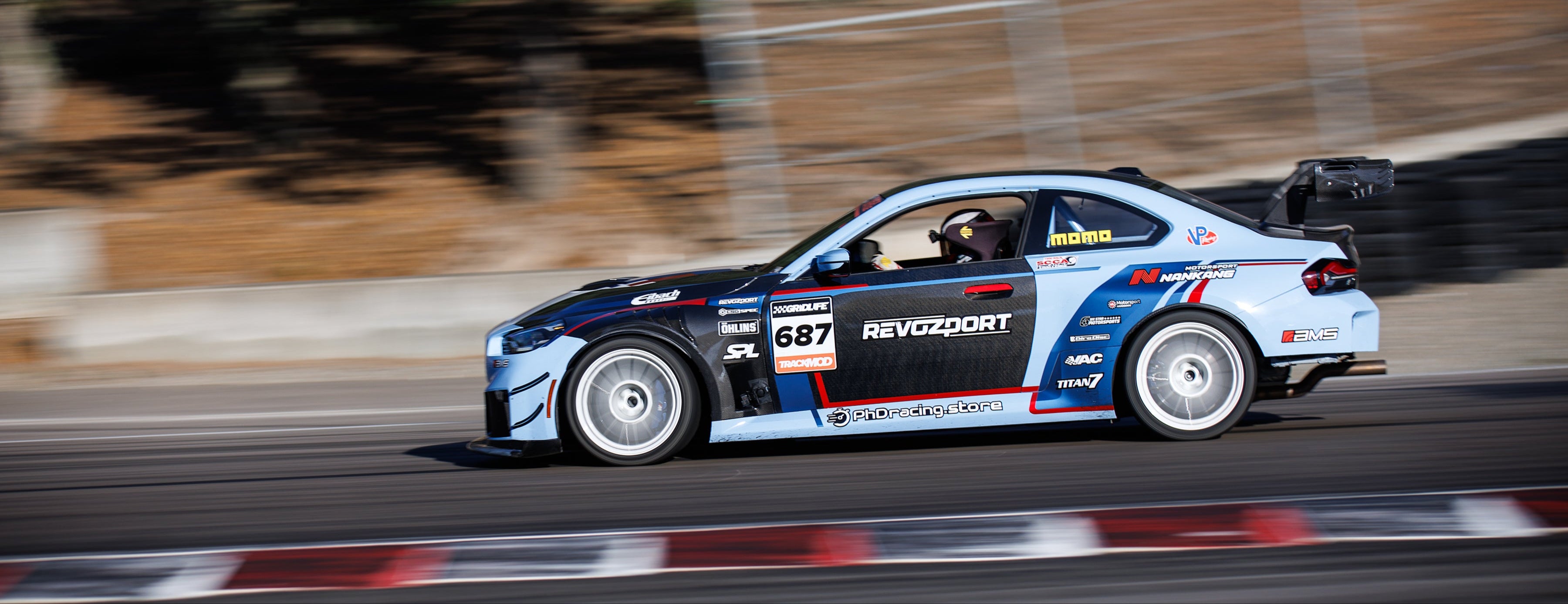 BMW carbon fibre kit, tearing around the track, surrounded by tyre barriers.
