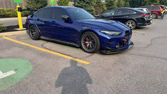 Close-up of a blue wide-body performance car featuring aggressive aerodynamic fender vents, extended side skirts, and lightweight multi-spoke wheels. The image highlights the custom bodywork, low-profile performance tire, and carbon fiber aero details in an outdoor automotive setting.