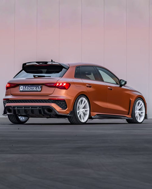 Bronze Audi RSQ8 featuring an aggressive REVOZPORT carbon fiber body kit with front lip, hood vents, side skirts, and custom front bumper design at sunset.