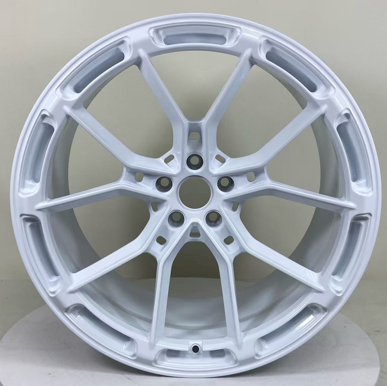 White REVOZPORT forged alloy wheel with lightweight split-spoke design displayed in a clean studio setting.