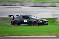 Rolling shot of a black BMW on racetrack, featuring oversized rear wing, aggressive carbon fiber aero, lowered stance, and motorsport wheel setup.