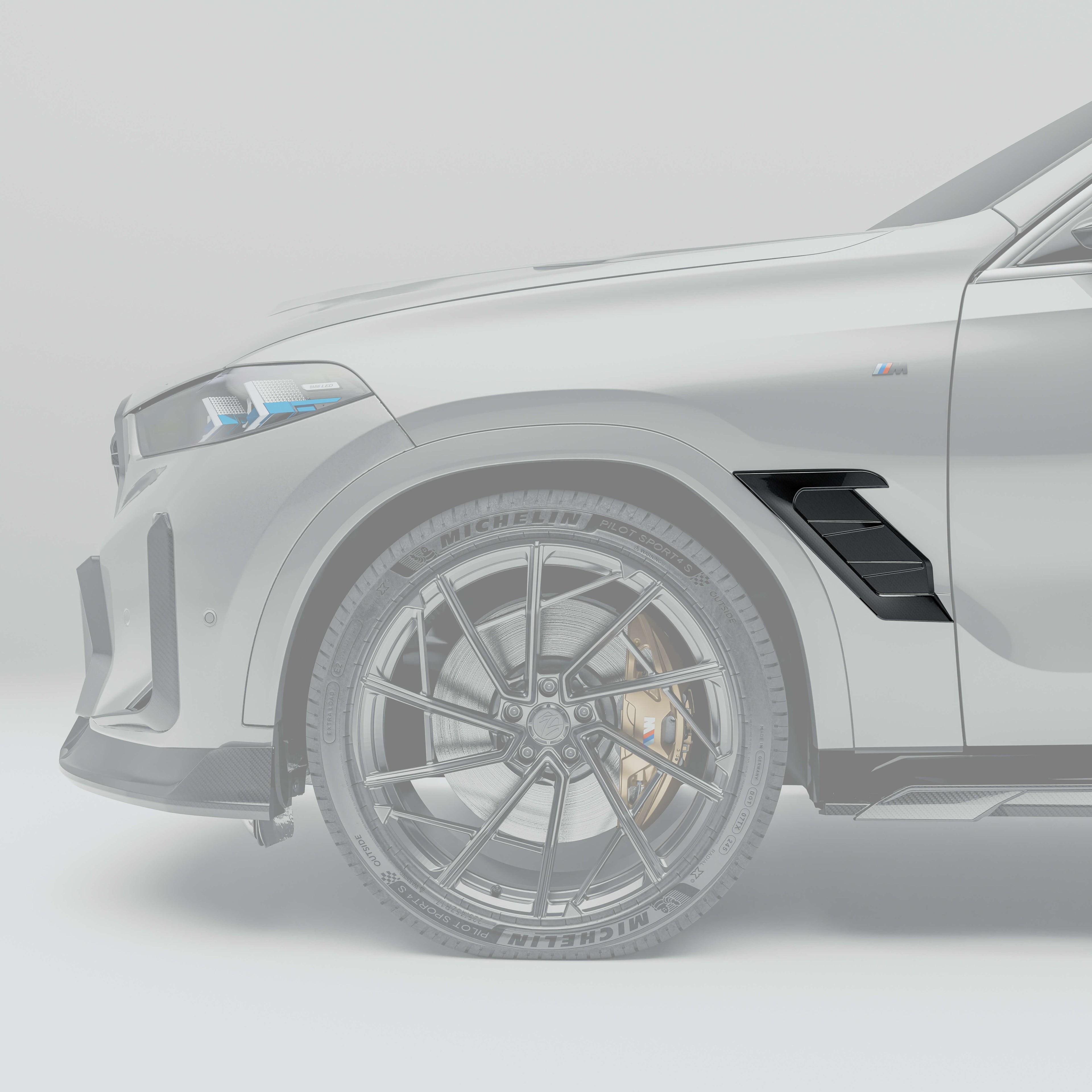 bmw-x6-g06:-close-up-of-the-carbon-fiber-fender-air-intake-against-a-gray-background